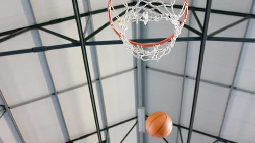 Punkte sammeln, Basketball in der Turnhalle durch einen Korb spielen, Copyspace