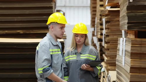Multiracial warehouse workers discussing inventory in the warehouse.
