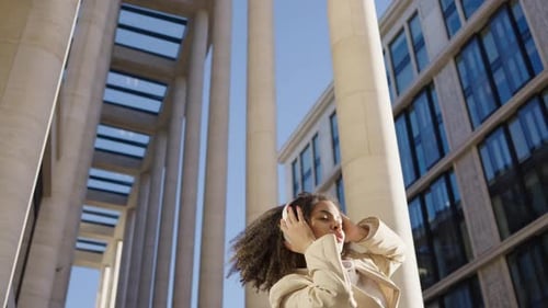 Stylish Woman Dancing to Music in Urban Setting