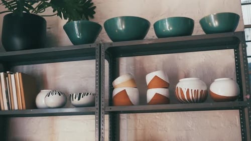 Pottery, art and ceramics on shelf in a store, workshop or studio for manufacturing display