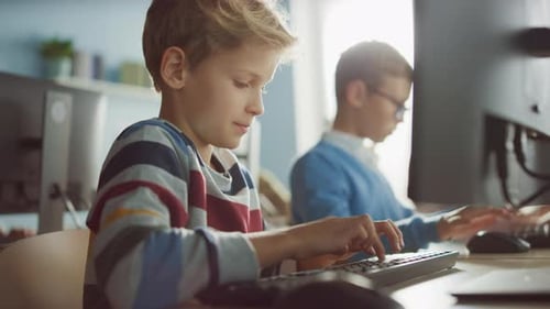 Elementary School Classroom: Smart Boy Uses Personal Computer, Learning How to Use Internet Safely,