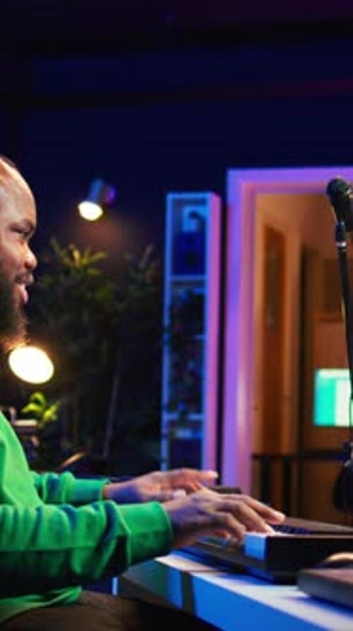 Man Plays Electronic Keyboard in Music Studio