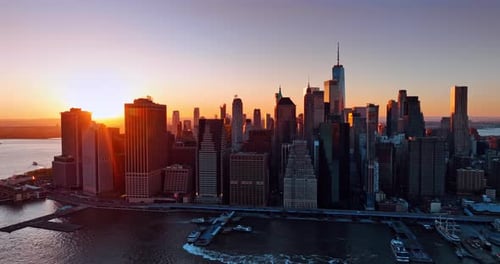 Orange light of setting sun covers the tops of New York skyscrapers.