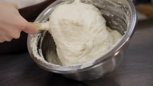 Closeup of a Girl Cook Mixing Dough with a Silicone Spatula in a Metal Bowl