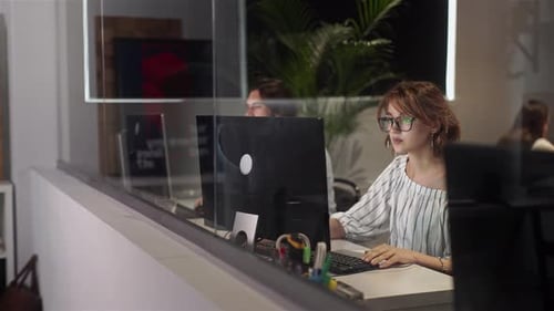 Young Woman Typing at Desk in Office