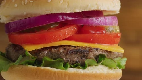 Delicious fresh hamburger close up with cheese and toppings shot on red 8k