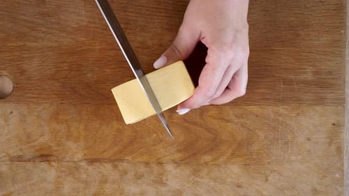 20 1Hard cheese is cut into slices with a knife. Cheese as an ingredient in dishes.