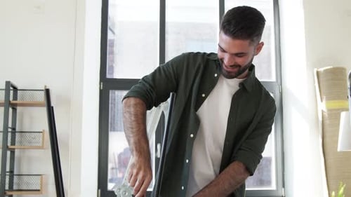 Man Assembling Furniture in Bright Modern Apartment