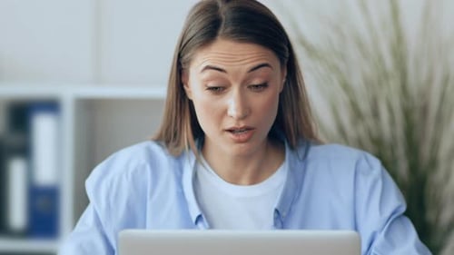 Young Woman Working on Laptop in a Modern Office Setting During the Day