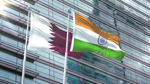 Qatar and India National Flags Waving on a Modern Corporate Building