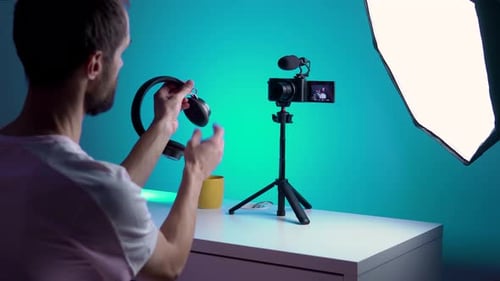 Un joven bloguero graba un vídeo consigo mismo en su teléfono en su estudio