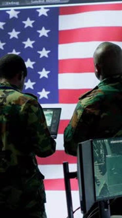 Figures Wearing Camouflage in Front of US Flag
