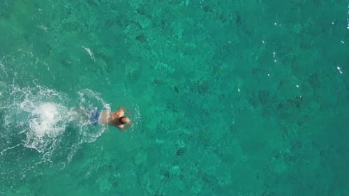 Aerial View of Young Man Swimming in the Sea