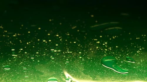 Vibrant Green Colored Water Surface with Oil Drops Blowing By Wind Abstract Background Slow Motion