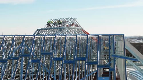 Industrielle Dachdecker, die ein Dach auf einem Industriegebäude oder einer Lagerhalle installieren, Luftaufnahmen