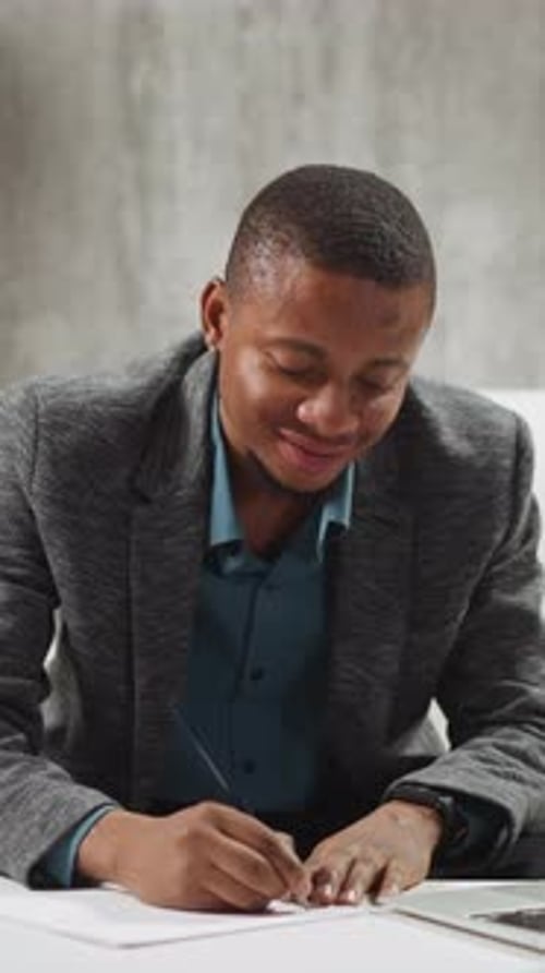 Young Adult Writing Carefully in Modern Office