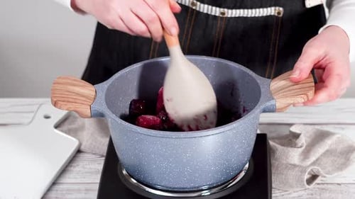Stirring Blueberries and Strawberries in Gray Pot