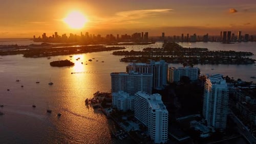 Boats and yachts on the waterscape of Biscayne Bay dazzled by setting sun.