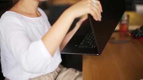 Mixed Race Freelancer Transforms Convertible Laptop Into Tablet While Working in Cafe Asian