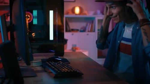 Smiling Young Man Plays Video Game at Home