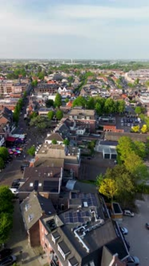 Top-down aerial view of a lively European street scene with colorful umbrellas, outdoor cafes