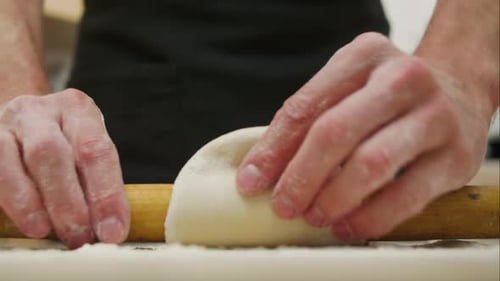 Rolling Pin with Dough on Wooden Table