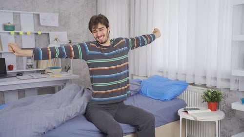 Young Man Wakes Up and Stretches in Bed