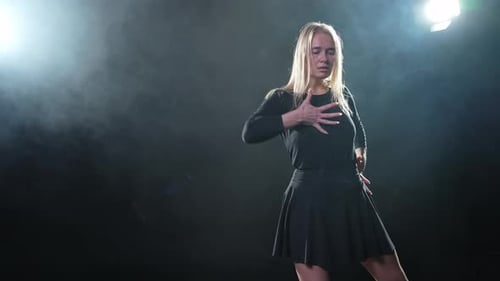 Zeitgenössische Tänzerin posiert auf schwarzem Hintergrund mit Rauch, erwachsene Künstlerin, Darstellerin