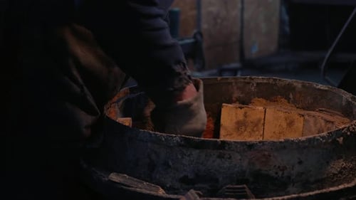 Close up ladle matrix being filled by man in metallurgucal workshop.