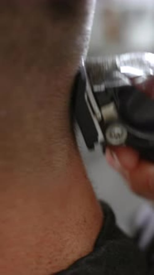 Friseur gibt einem Mann einen Haarschnitt mit elektrischem Haarschneideclip