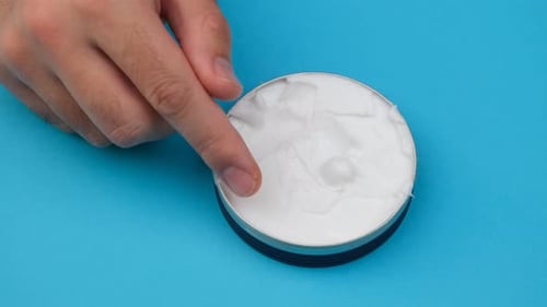 Finger Dipping into White Cream Product