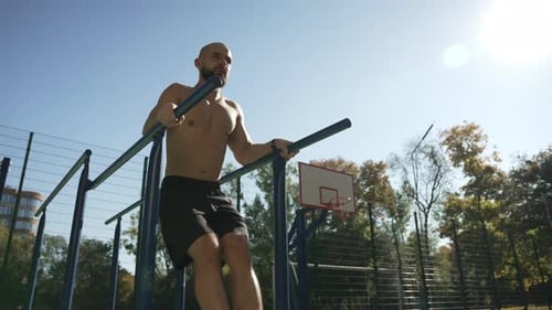 A Young Man is Pumping His Abs in the Fresh Air