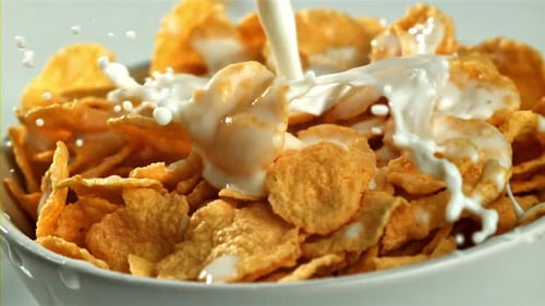 Pouring Milk on Cornflakes in Bowl Close Up
