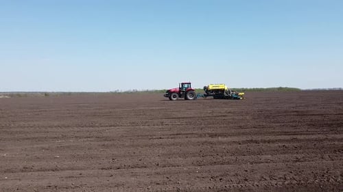 Tractor with yellow seeder working on the field in Ukraine OA Lexa