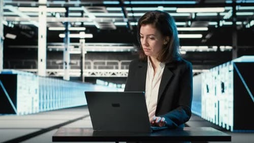 Data Center Engineer Typing on Laptop Keyboard to Troubleshoot Issues