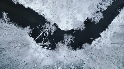 Aerial view of Brda River and snowy forest in winter.