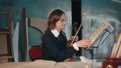 Young Woman with Violin Studying Sheet Music