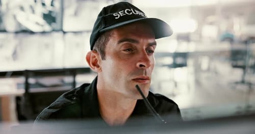 Security Guard Communicates with Walkie Talkie in Control Room