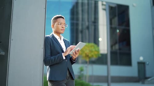 Businesswoman Using Tablet Outside Office Building