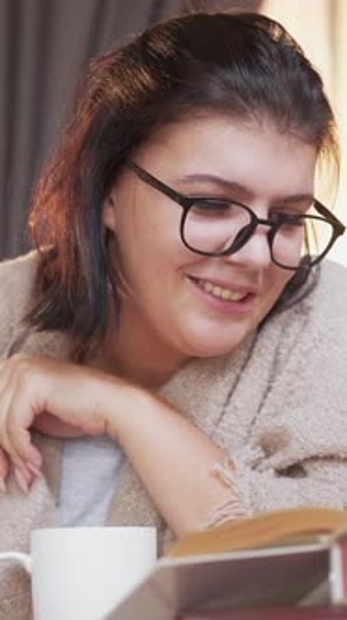 Smiling Woman Reading a Book Indoors