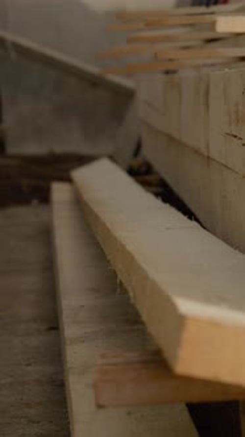 Vertical video Wooden beams drying process in a workshop setting for construction purposes