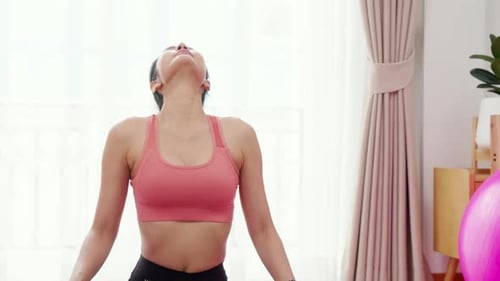 Woman Practices Relaxing Yoga at Home During Daytime