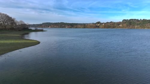 Photographer With His Camera On Tripod Near Scenic Lake - Drone Pullback