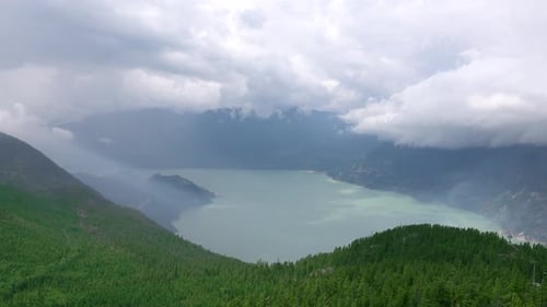 The lake surrounded by misty fog, mountains and forests is full of mystery.