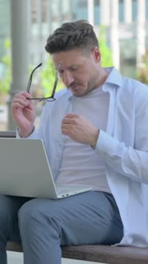 Man Working on Laptop Computer Outside on Bench
