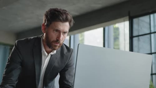 Serious 40s Bearded Businessman Entrepreneur Employee Standing in Office Looking at Papers Report