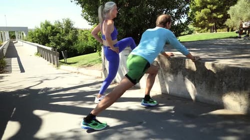 Mature athletes stretching legs before running, embodying fitness and active lifestyle in vibrant ur