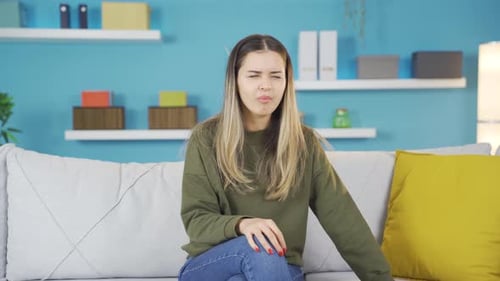 Young Woman Coughing on a Couch Indoors