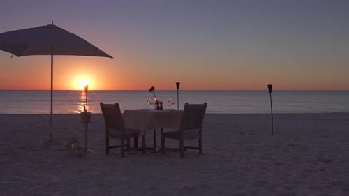 Romantic Table on the Beach Set for Two at Sunset Aerial