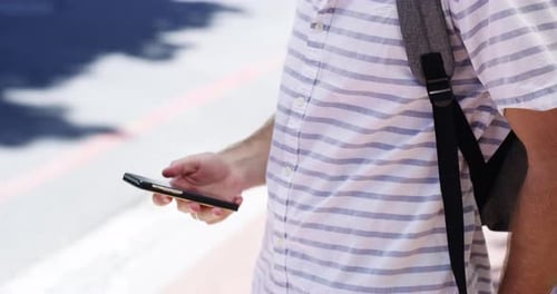 4k video footage of an unrecognizable man sending text messages while out in the city